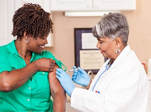 Doctor Gives Flu Vaccine to Patient at Clinic